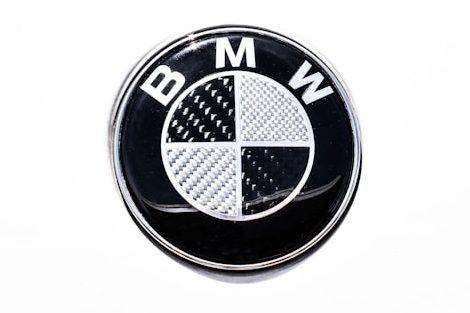 Rundes BMW-Logo mit schwarz-weißer viertelgeteilten Fläche und emblemloser Schrift.