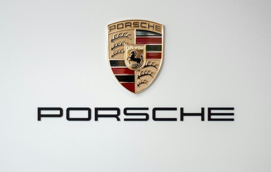 Porsche-Logo mit Wappen und Schriftzug auf neutralem Hintergrund.