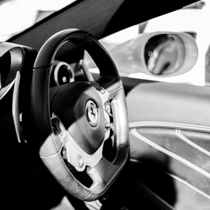 Schwarzes Lenkrad und Armatur eines modernen Autos, mit Spiegelansicht.