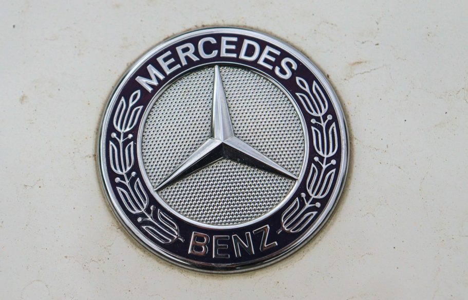 Rundes Mercedes-Benz-Logo mit Stern und lilafarbenem Rand.